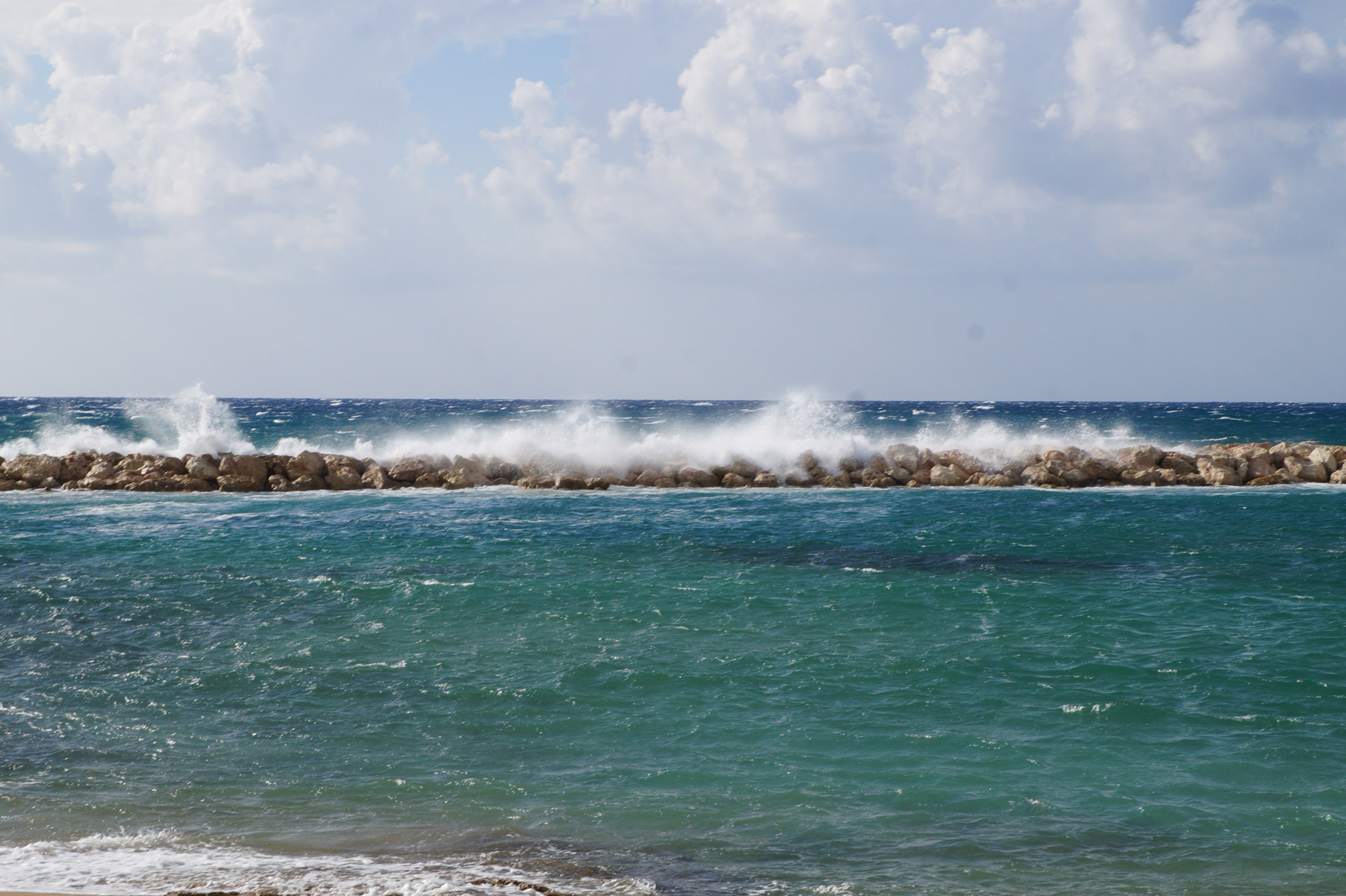 Волны разбиваются в мелкие брызги о волнорез.
Пафос, Кипр, осень 2018